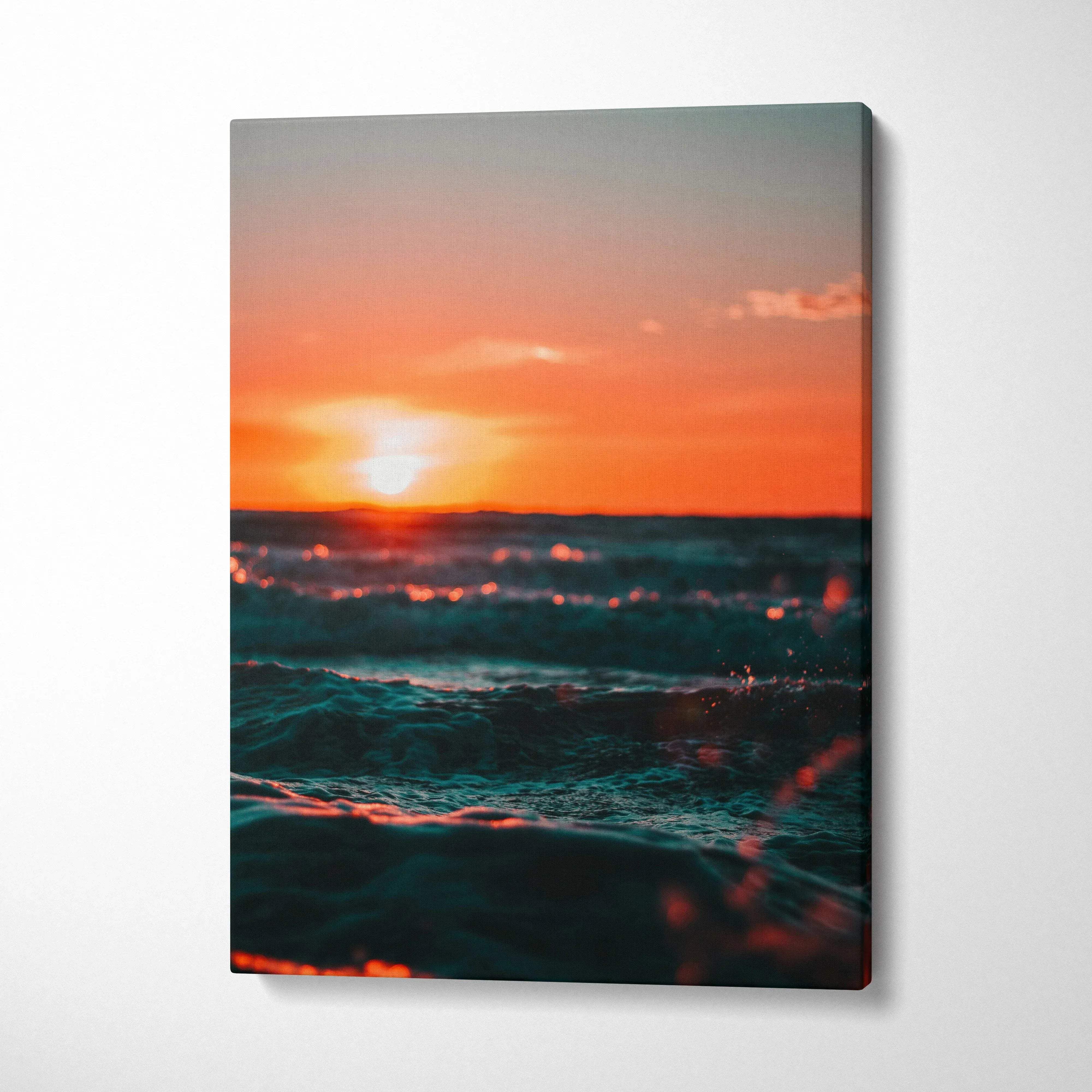 Vertical canvas wall art featuring a vibrant ocean sunset with glowing waves and warm orange sky.