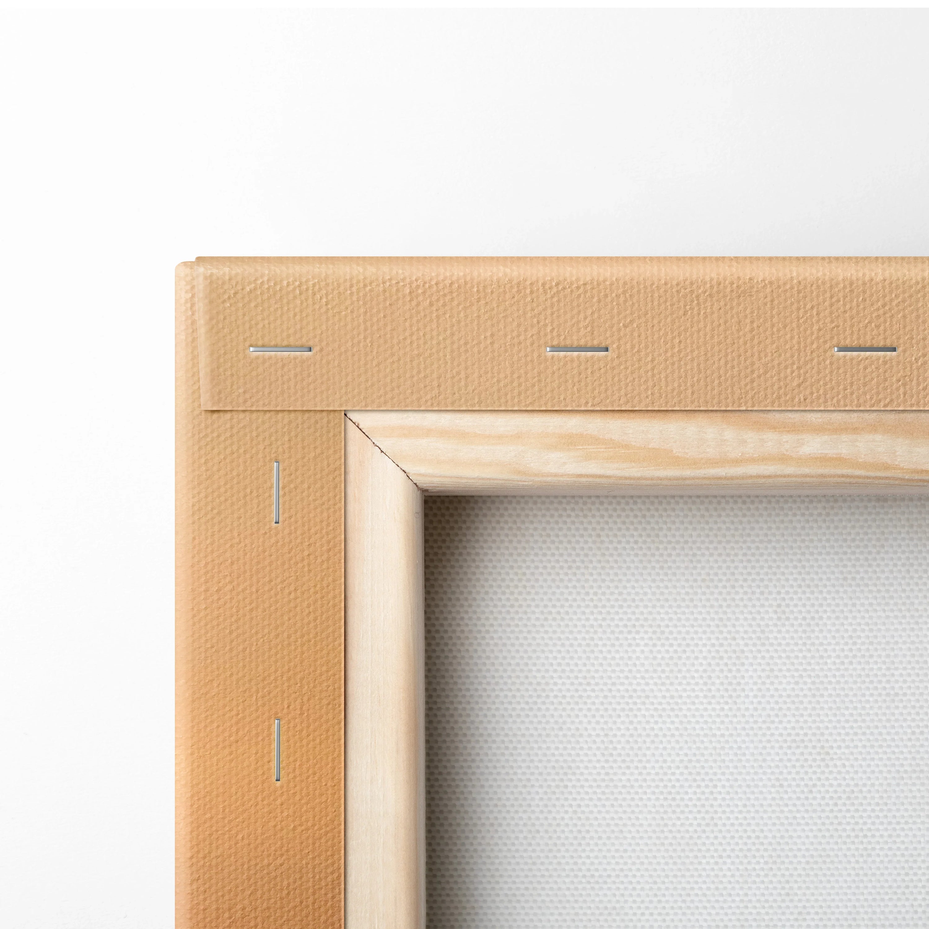 Close-up of stretched canvas fabric on a wooden frame corner for wall art display.
