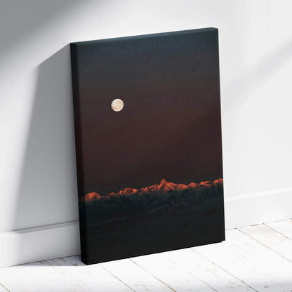 Vertical canvas wall art featuring a dark mountain landscape with glowing moon and orange-tipped peaks.