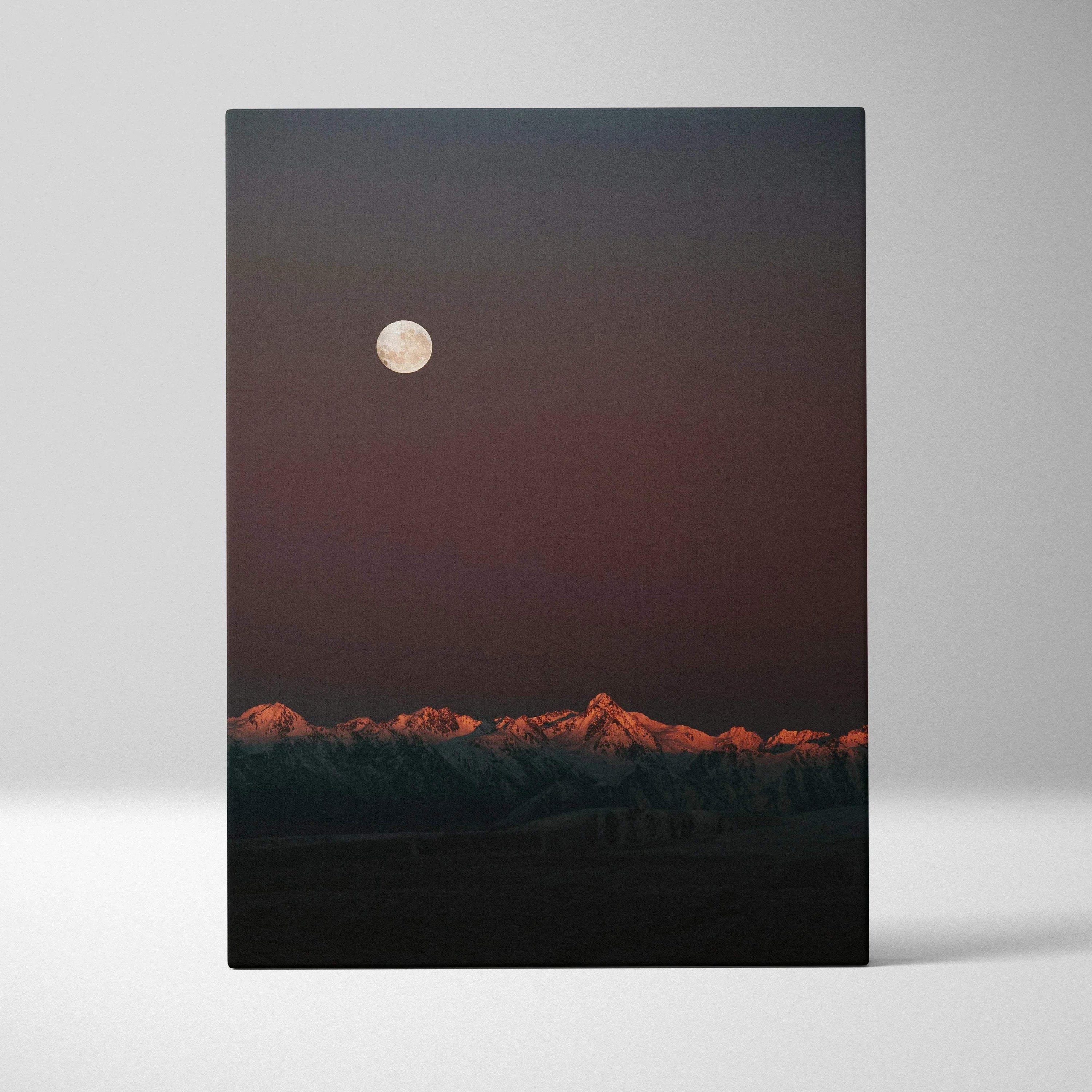Canvas wall art featuring a glowing full moon above a mountain range at dusk with warm light on the peaks.