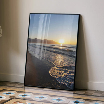 Beach sunset poster wall art with waves and sun over distant mountains in vertical format.