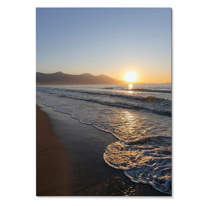 Vertical beach sunset poster with glowing sun, gentle waves, and distant mountains wall art.