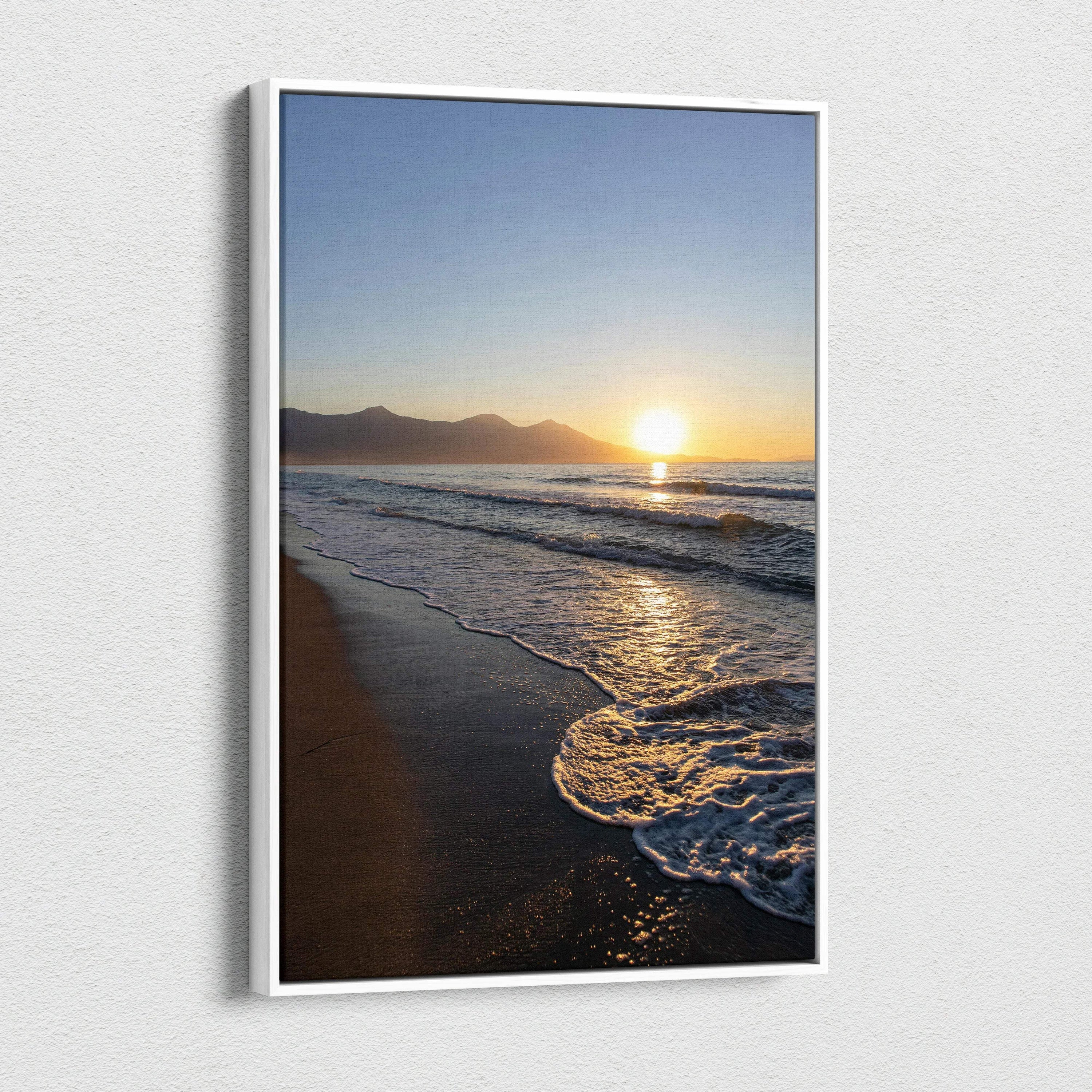 Vertical canvas wall art featuring a mountain sunset over a beach with waves gently lapping the shore.