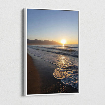 Vertical canvas wall art featuring a mountain sunset over a beach with waves gently lapping the shore.