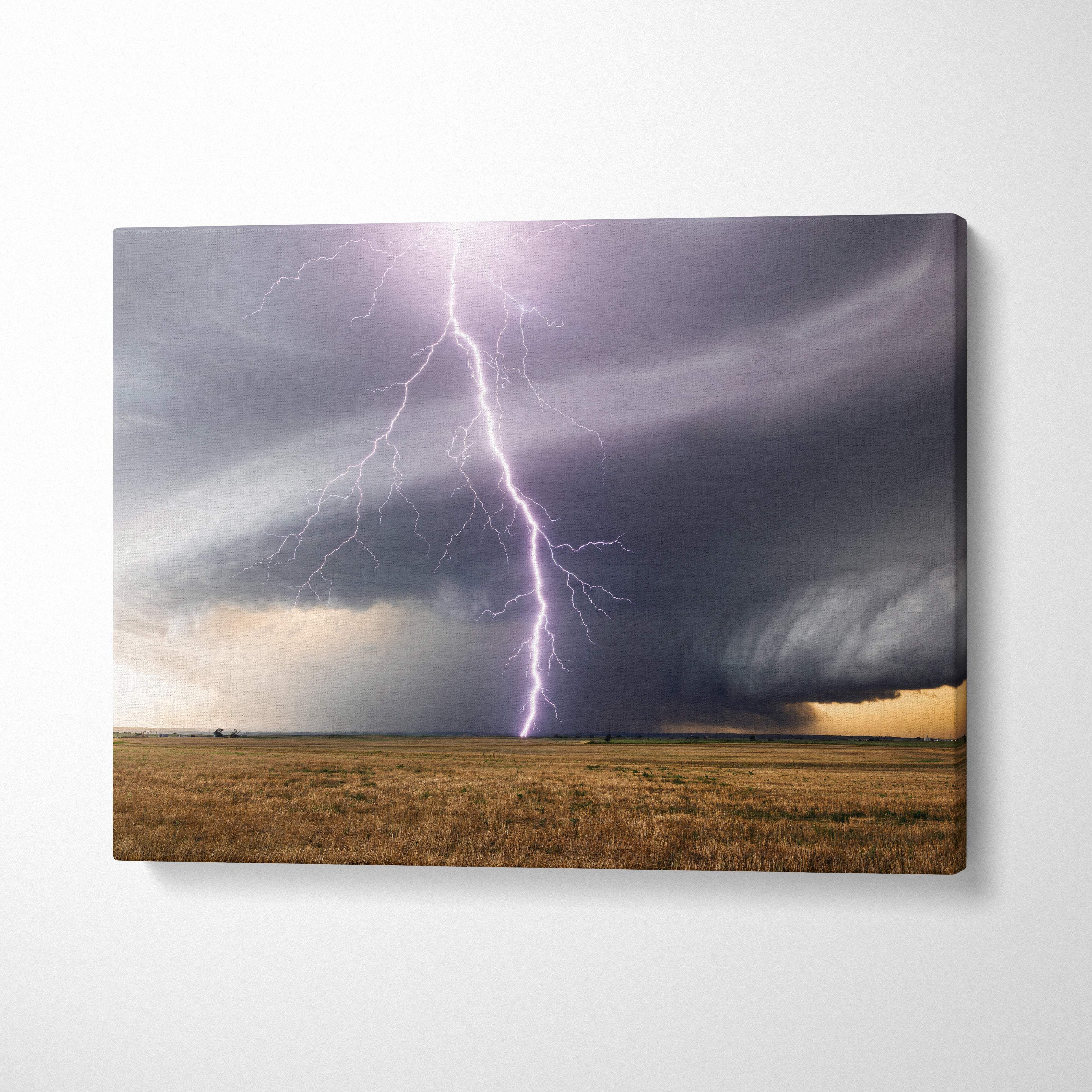 Canvas print of a dramatic purple lightning strike with dark rotating storm clouds over an open plains landscape wall decor