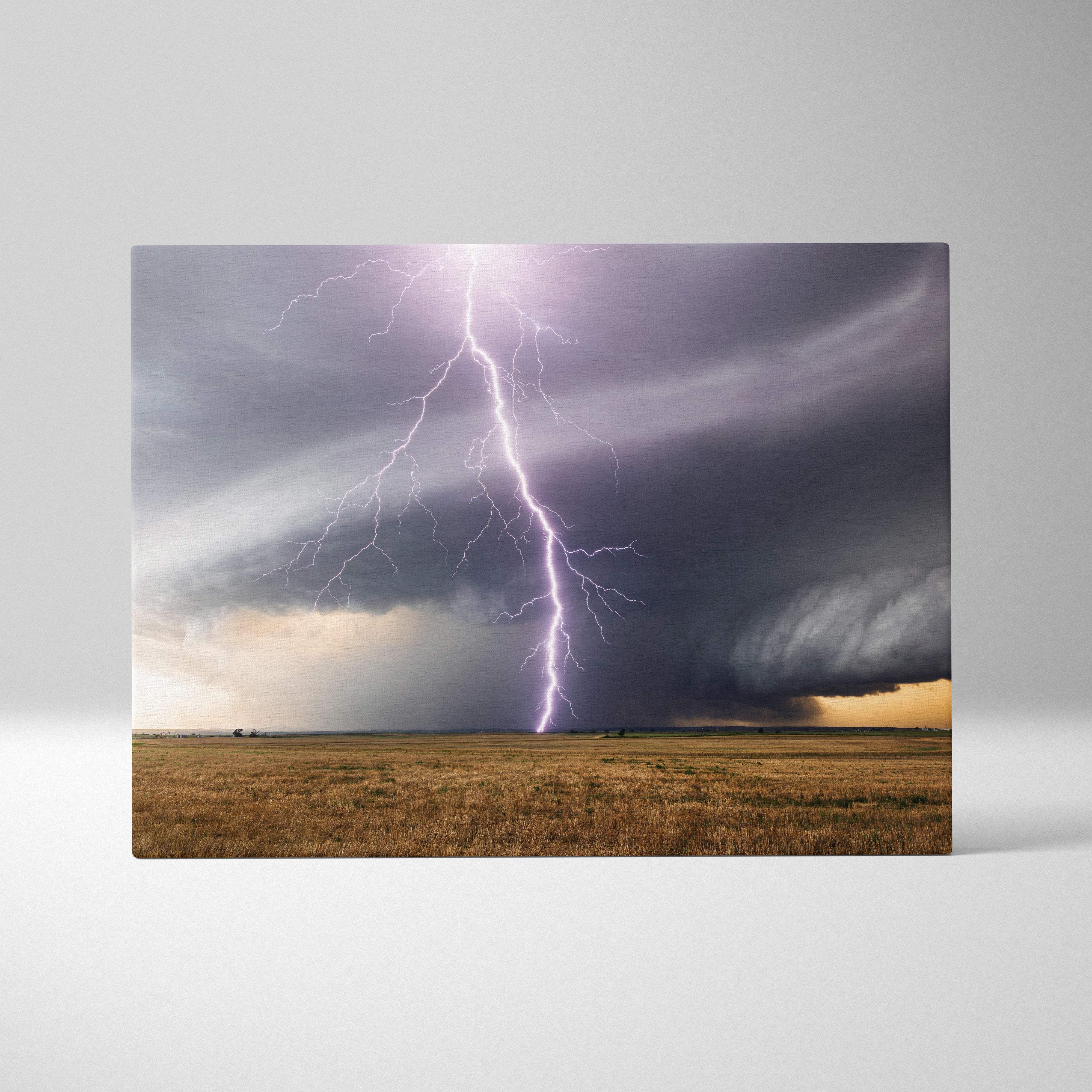 Lightning strike supercell canvas art with a purple bolt and dark rotating storm clouds over a golden field landscape wall decor