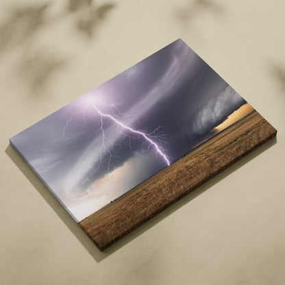 Canvas print of a dramatic purple lightning bolt striking dark rotating storm clouds over a golden field in a rustic wooden frame