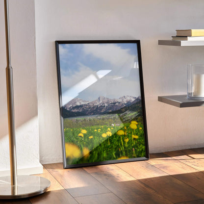 Vertical poster wall art featuring majestic snow-capped mountains and a green meadow with yellow flowers.