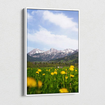 Canvas wall art featuring a mountain landscape with a blue sky and yellow wildflowers in the foreground.
