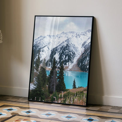 Vertical poster wall art of snow-capped mountains and turquoise lake with pine trees in foreground.