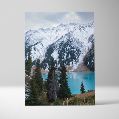 Canvas wall art featuring snow-capped mountain peaks above turquoise lake and evergreen trees.