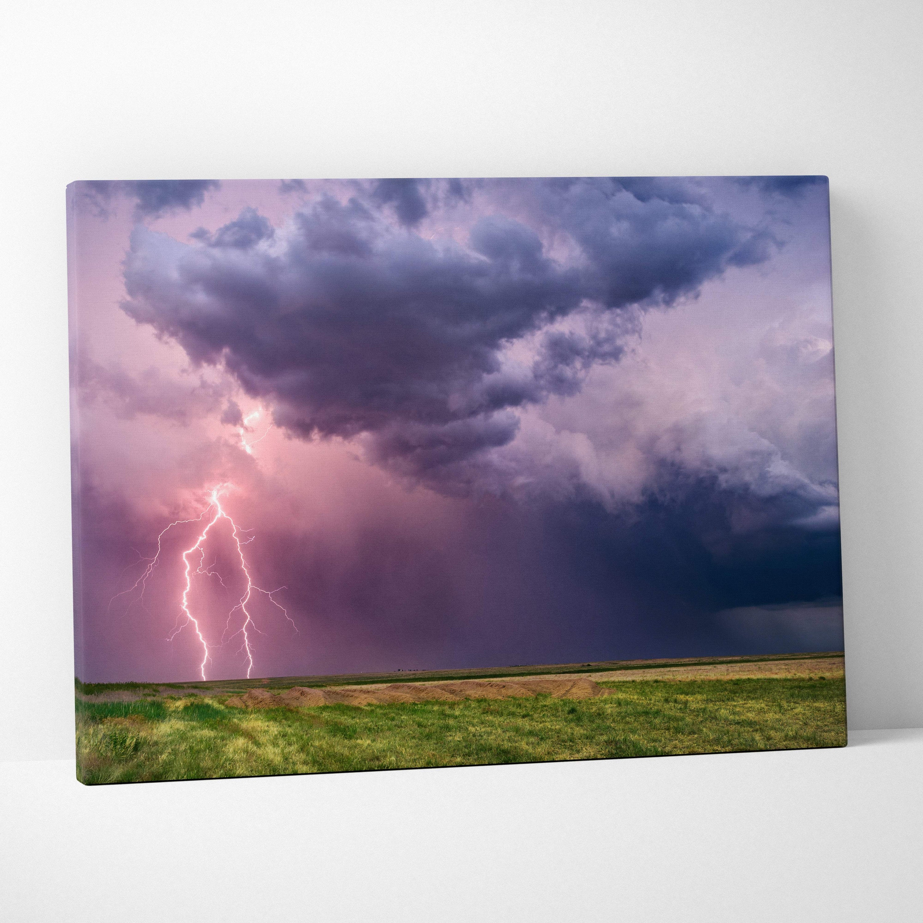 Canvas print of a dramatic lightning strike over a purple and pink stormy sky above a green field moody landscape wall art