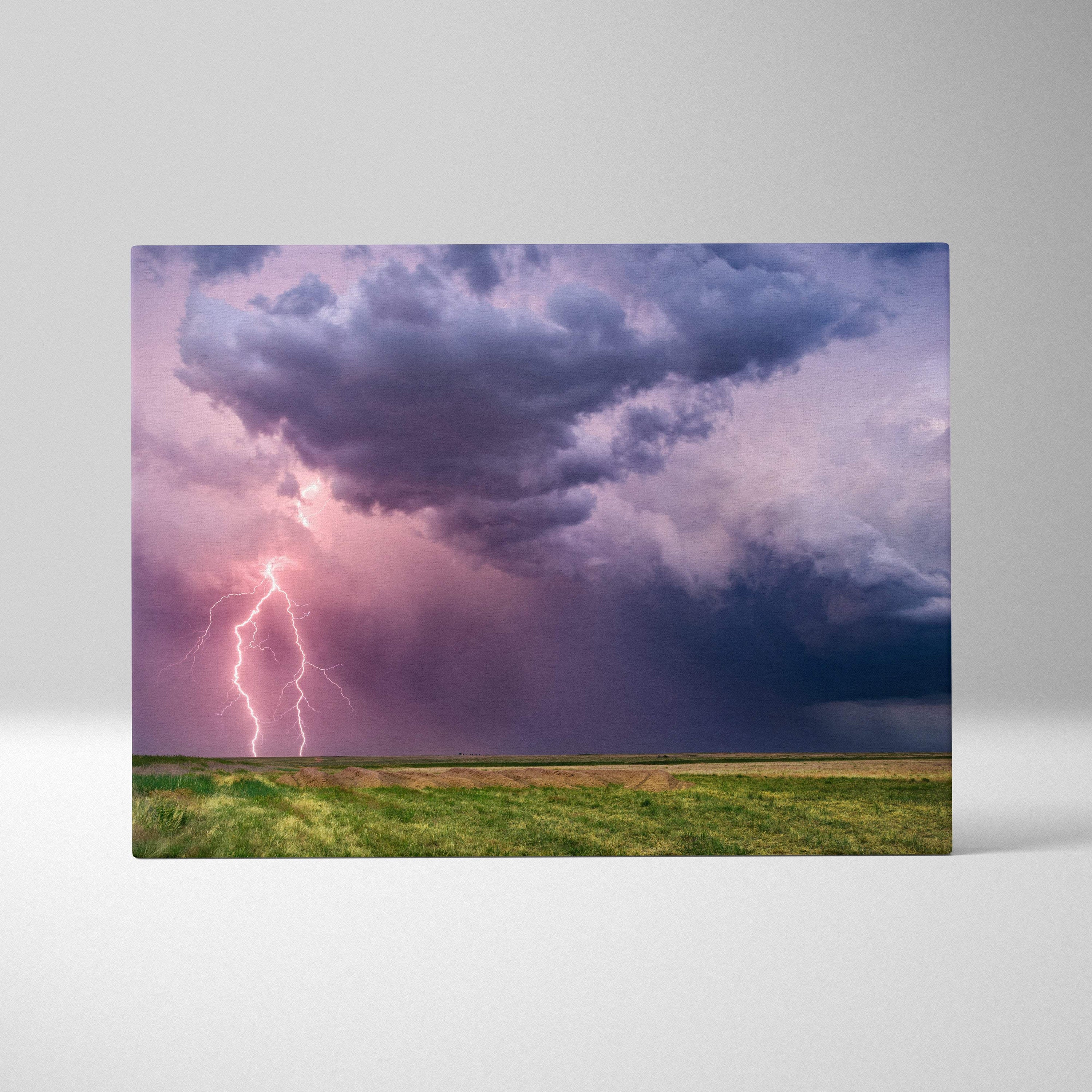 Rectangular canvas print of a dramatic lightning storm with purple and pink sky over a green field wall decor