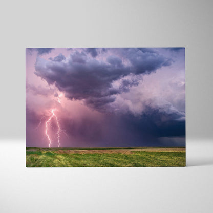 Rectangular canvas print of a dramatic lightning storm with purple and pink sky over a green field wall decor