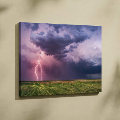 Canvas print of dramatic lightning storm with purple and pink sky over green field moody cinematic landscape wall decor
