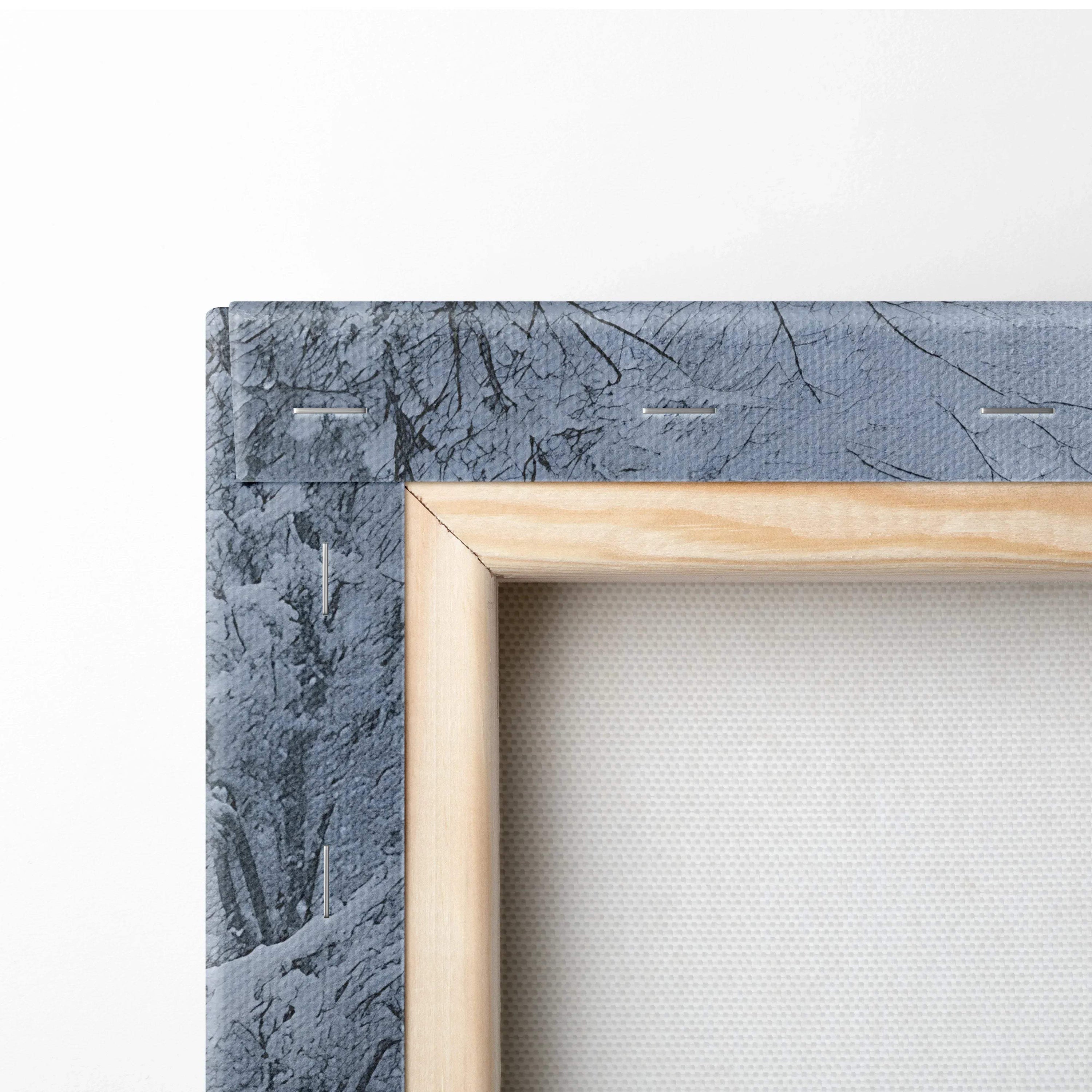 Close-up of wooden frame corner on textured snowy landscape canvas wall art print.