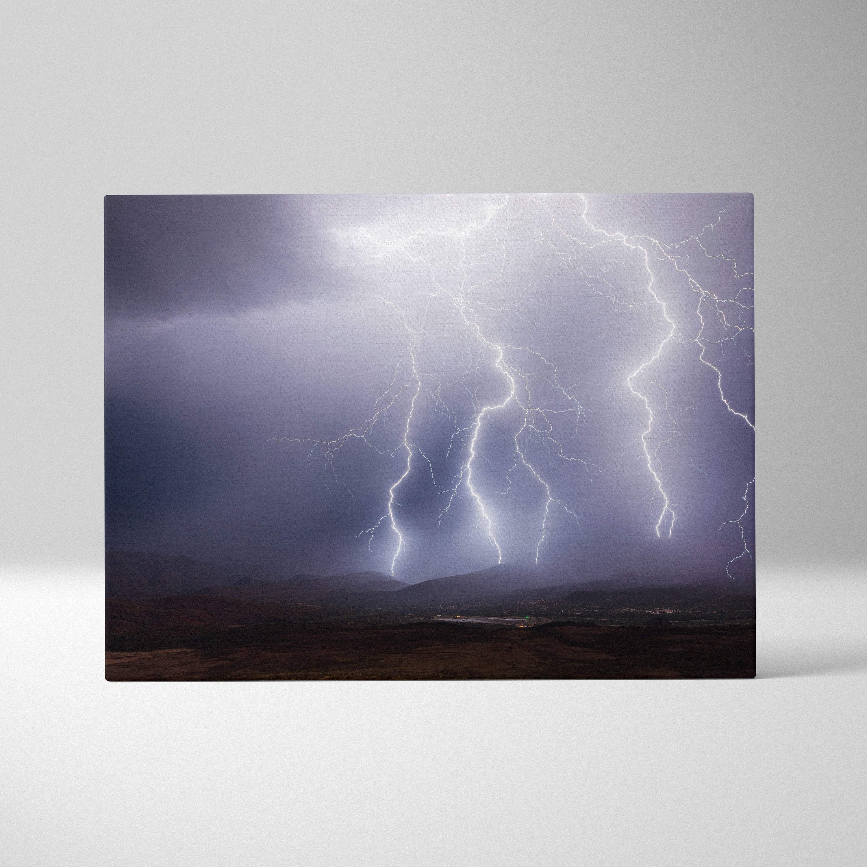 Canvas print of multiple bright white lightning bolts striking over dark moody hills in dramatic mountain landscape