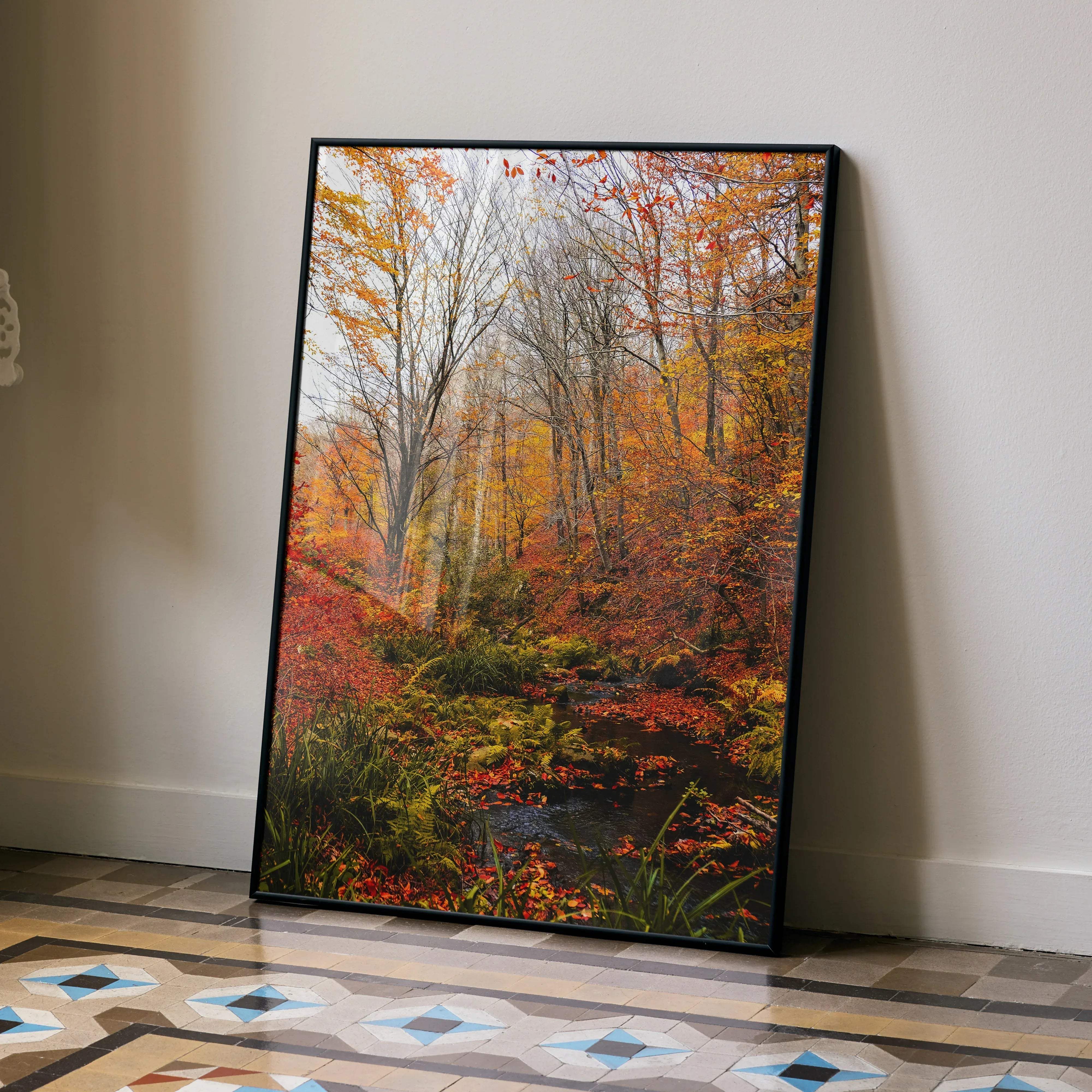 A framed vertical autumn forest nature wall art poster featuring vibrant orange red and yellow foliage with a black frame