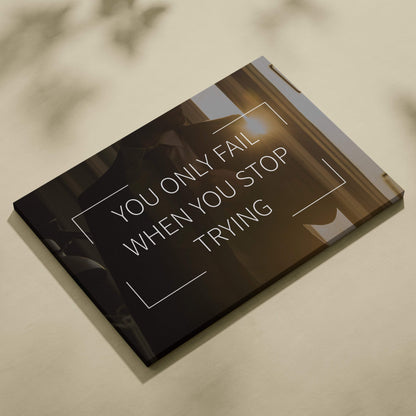 Black canvas print with motivational you only fail when you stop trying quote in white sans-serif for office decor