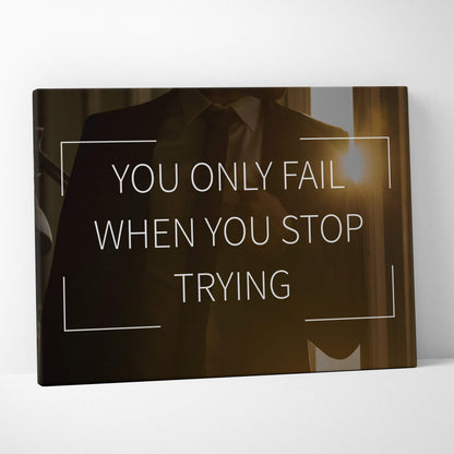 Black canvas print with motivational quote you only fail when you stop trying in white sans-serif lettering with geometric lines