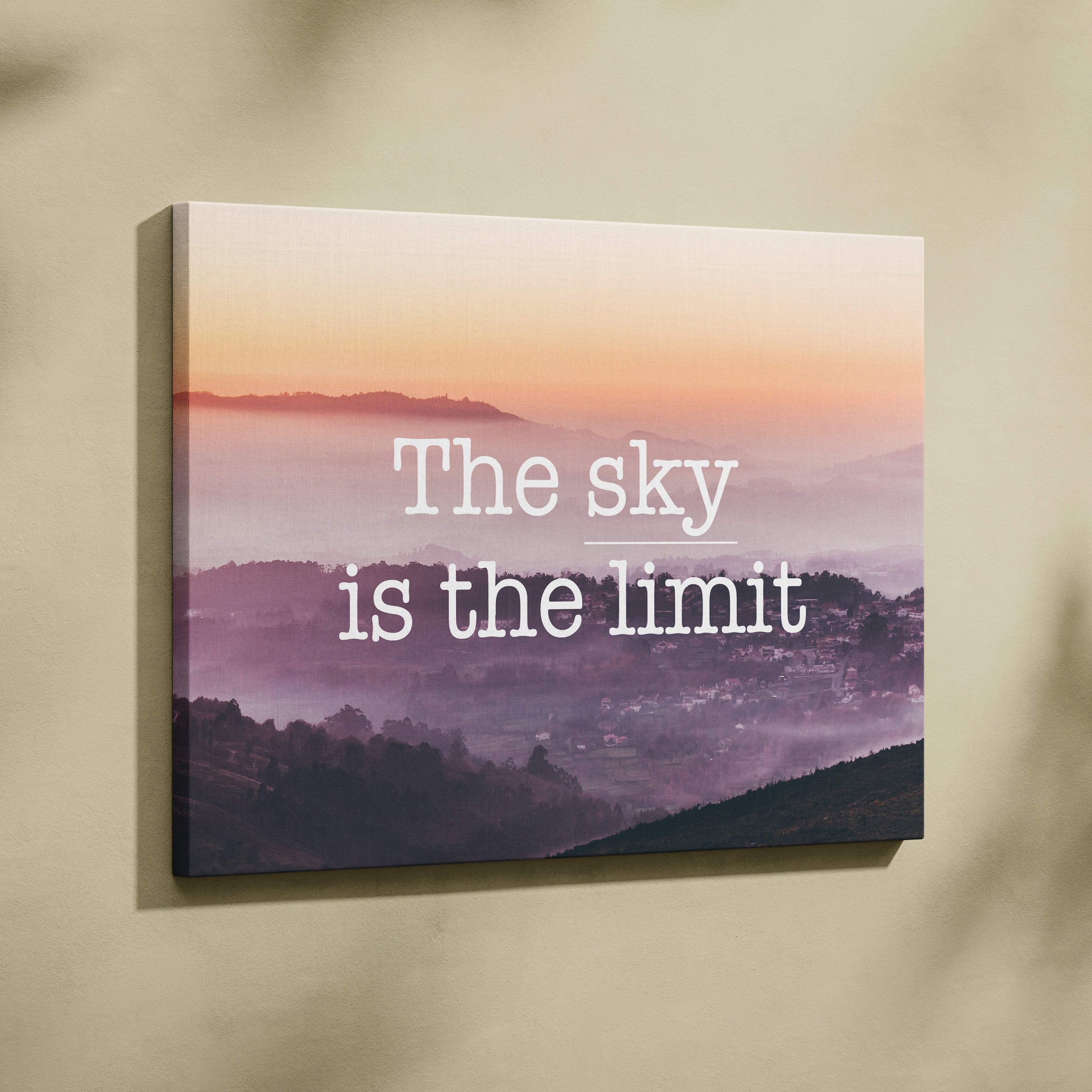 Rectangular canvas print of a pink and purple misty mountain landscape at sunrise with motivational sky is the limit text