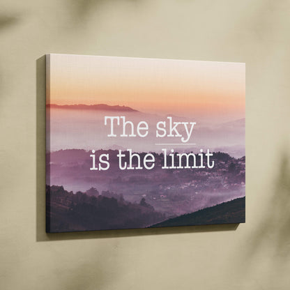 Rectangular canvas print of a pink and purple misty mountain landscape at sunrise with motivational sky is the limit text