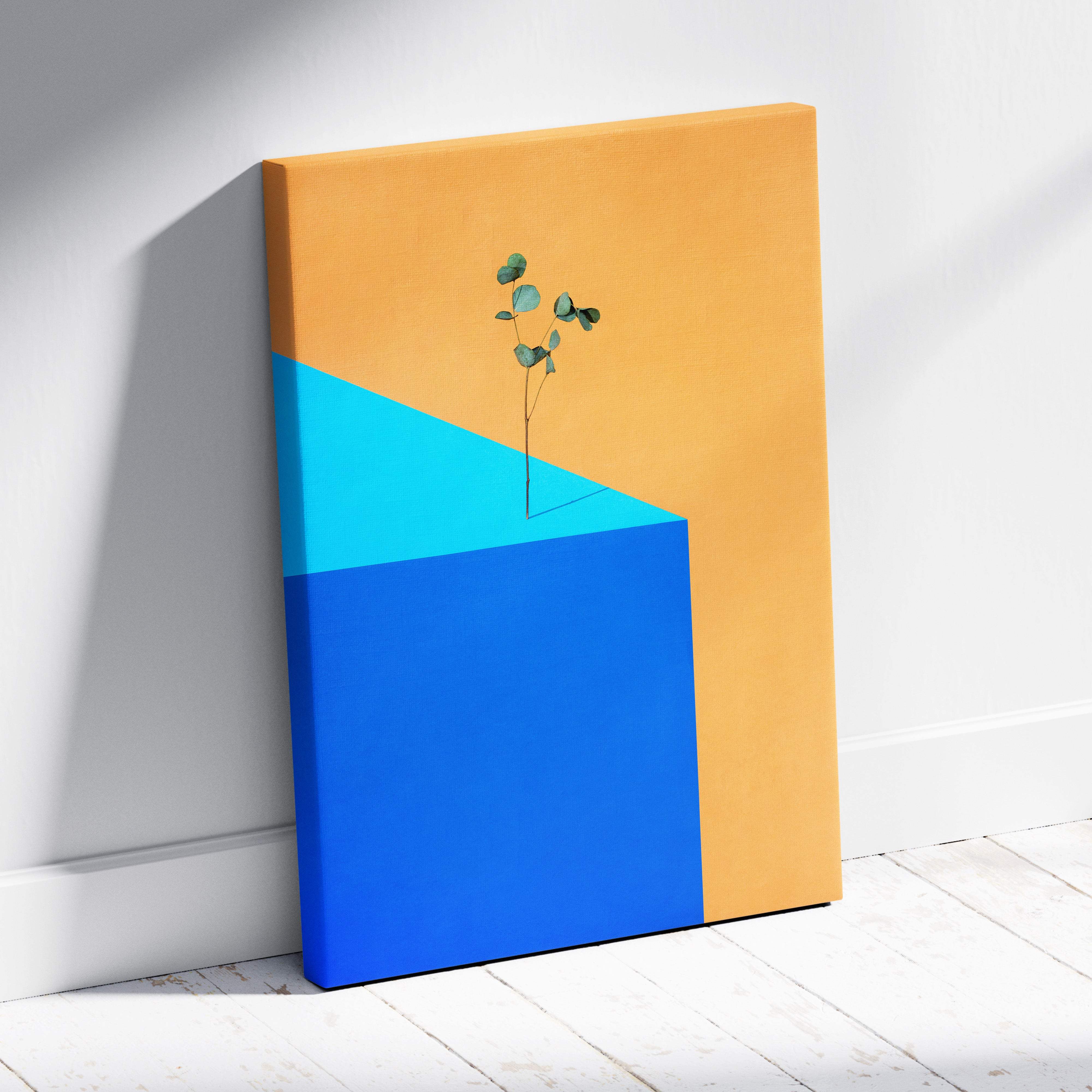 Contemporary eucalyptus canvas wall art with a delicate green sprig on bold orange and blue geometric shapes