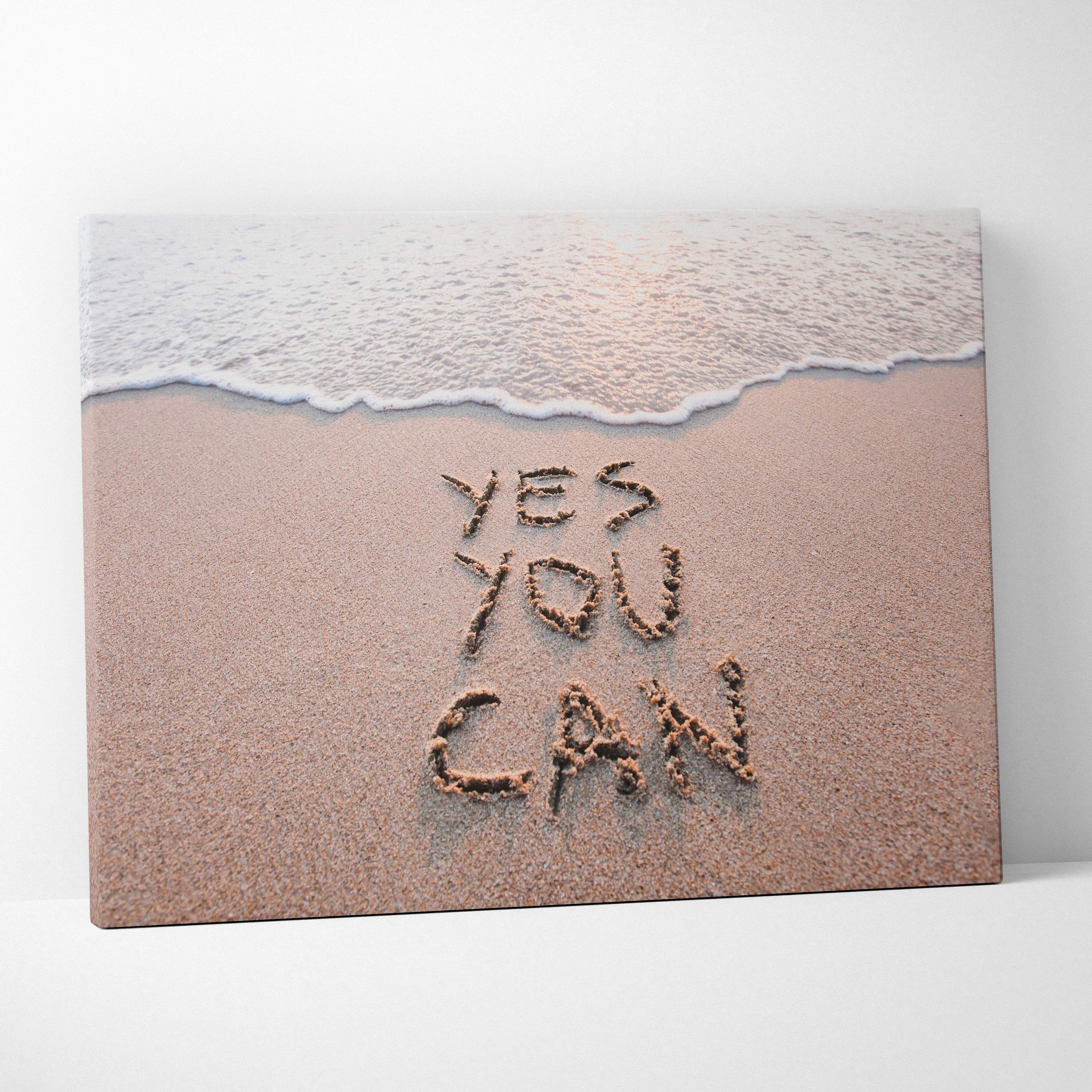 Beige canvas print with yes you can written in sand and a gentle wave, motivational coastal wall art decor