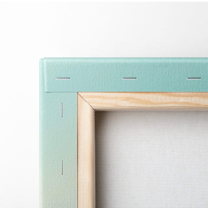 A mint green canvas frame with light wood inner border featuring snowy mountain explorer alpine wall art