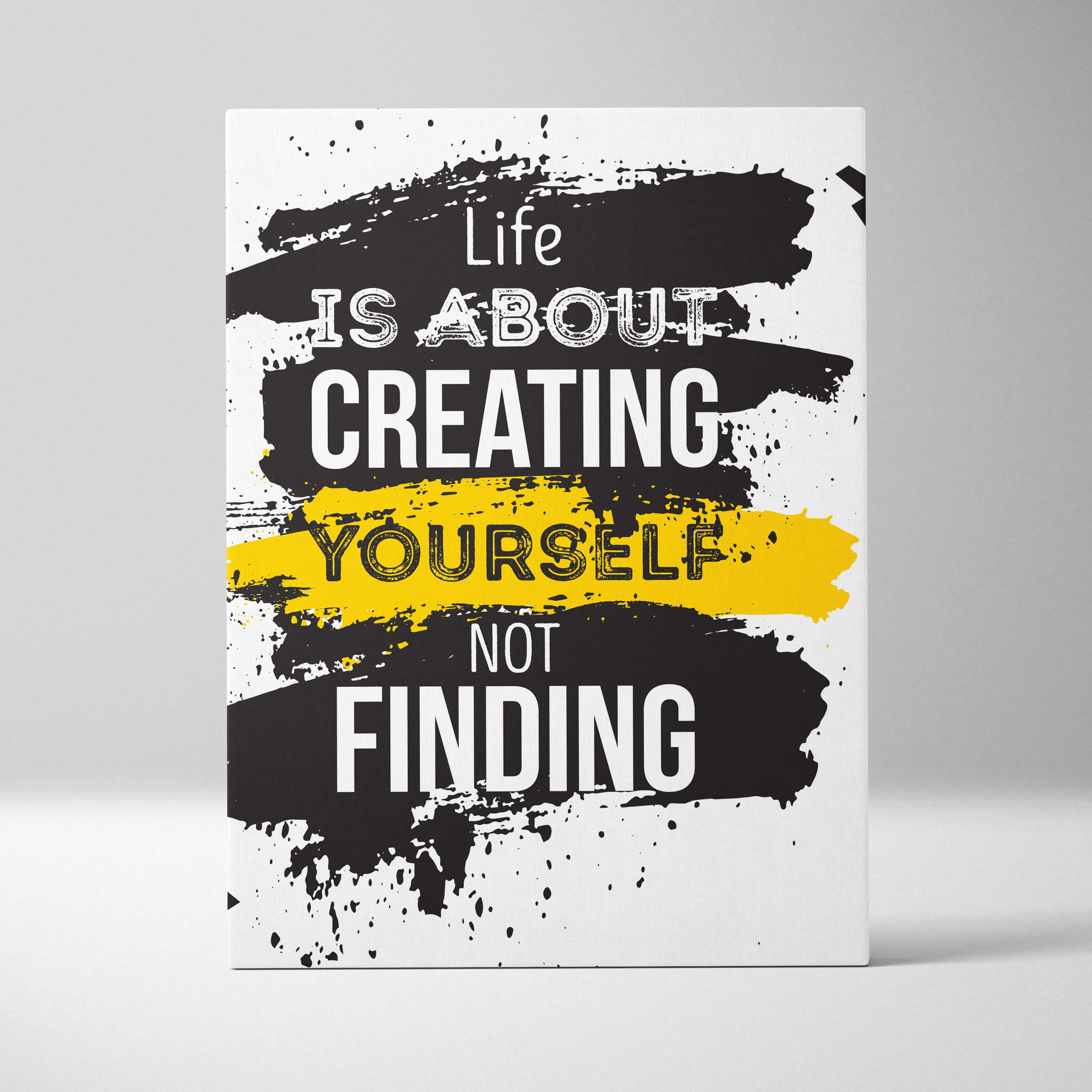 White canvas print with bold black and yellow brushstroke design featuring life is about creating yourself quote