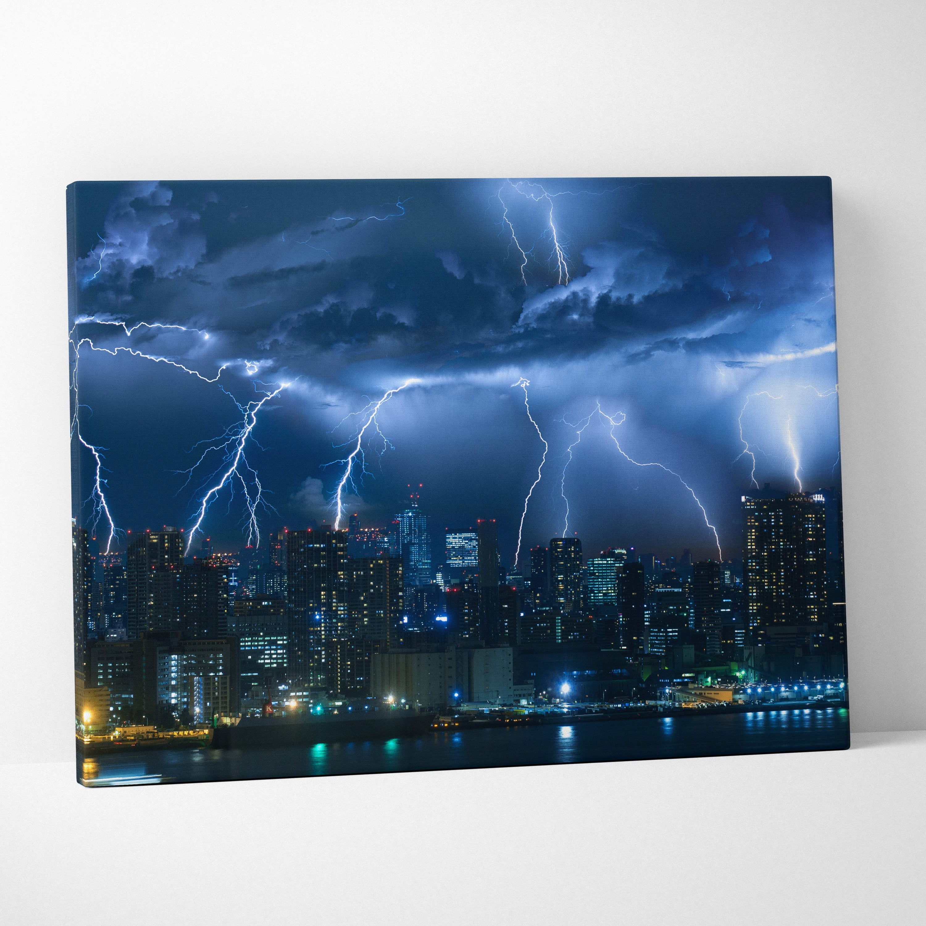 Canvas print of a city skyline at night with electric blue lightning strikes in a dramatic thunderstorm scene