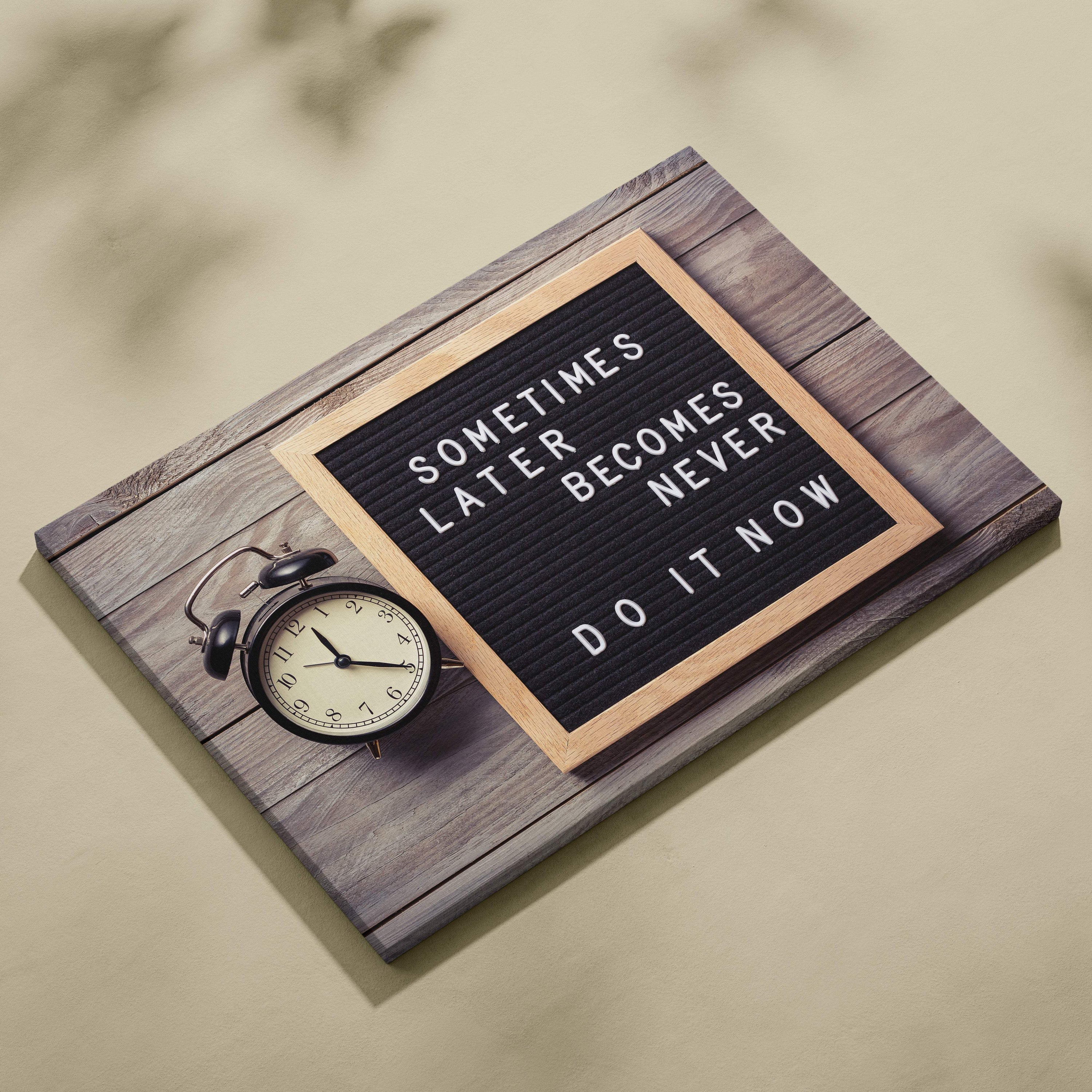 Motivational office canvas wall art with black letter board and wooden frame displaying sometimes later becomes never do it now quote