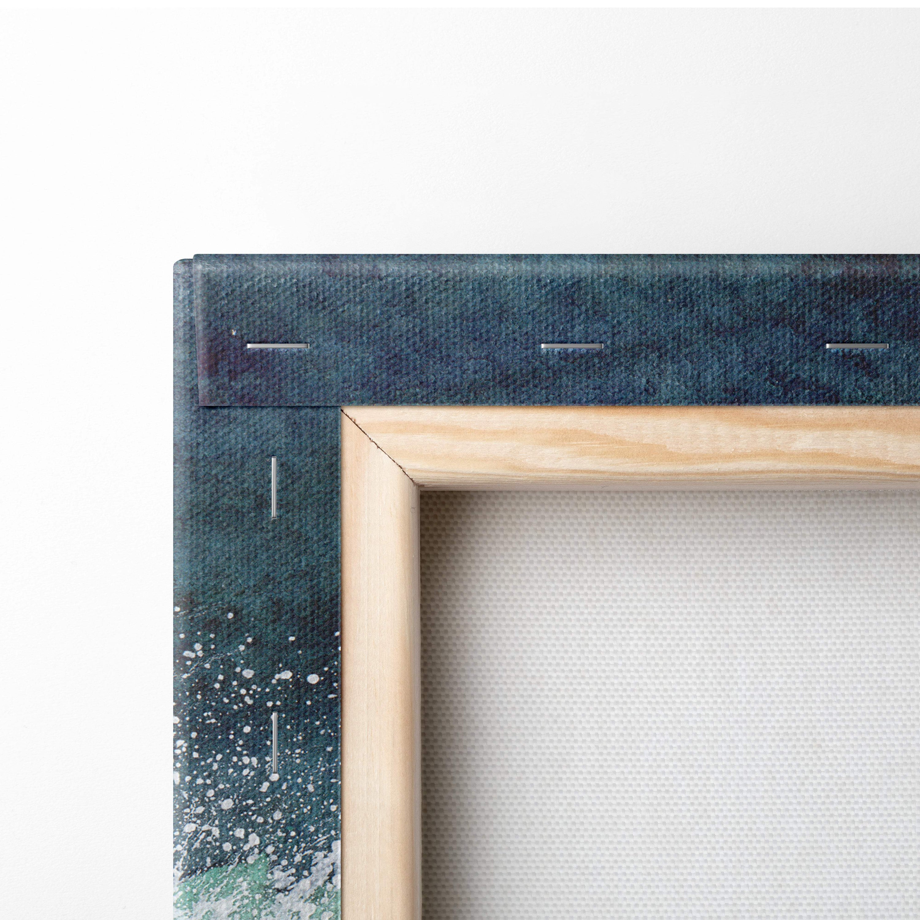 Light wood-framed canvas art with dark teal and white abstract splatter inspired by ocean waves for coastal decor
