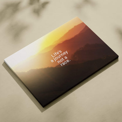 Motivational mountain sunset canvas wall art with warm orange gradient and inspiring life is a journey not a race quote