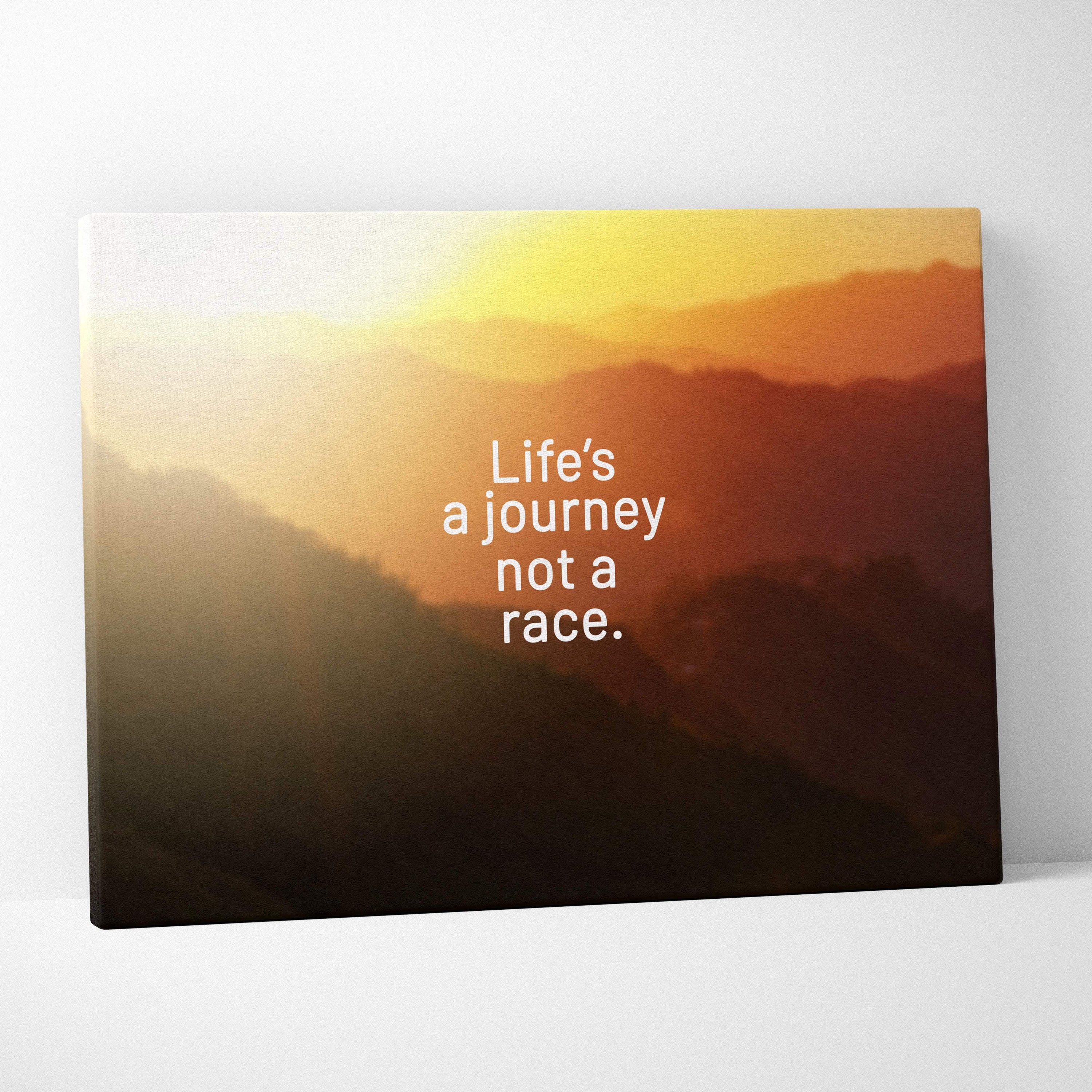 Motivational mountain sunset canvas wall art with warm orange layered mountains and life’s a journey not a race quote