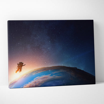 Astronaut earth orbit canvas wall art print featuring an astronaut floating in space with blue starry sky and orange earth horizon