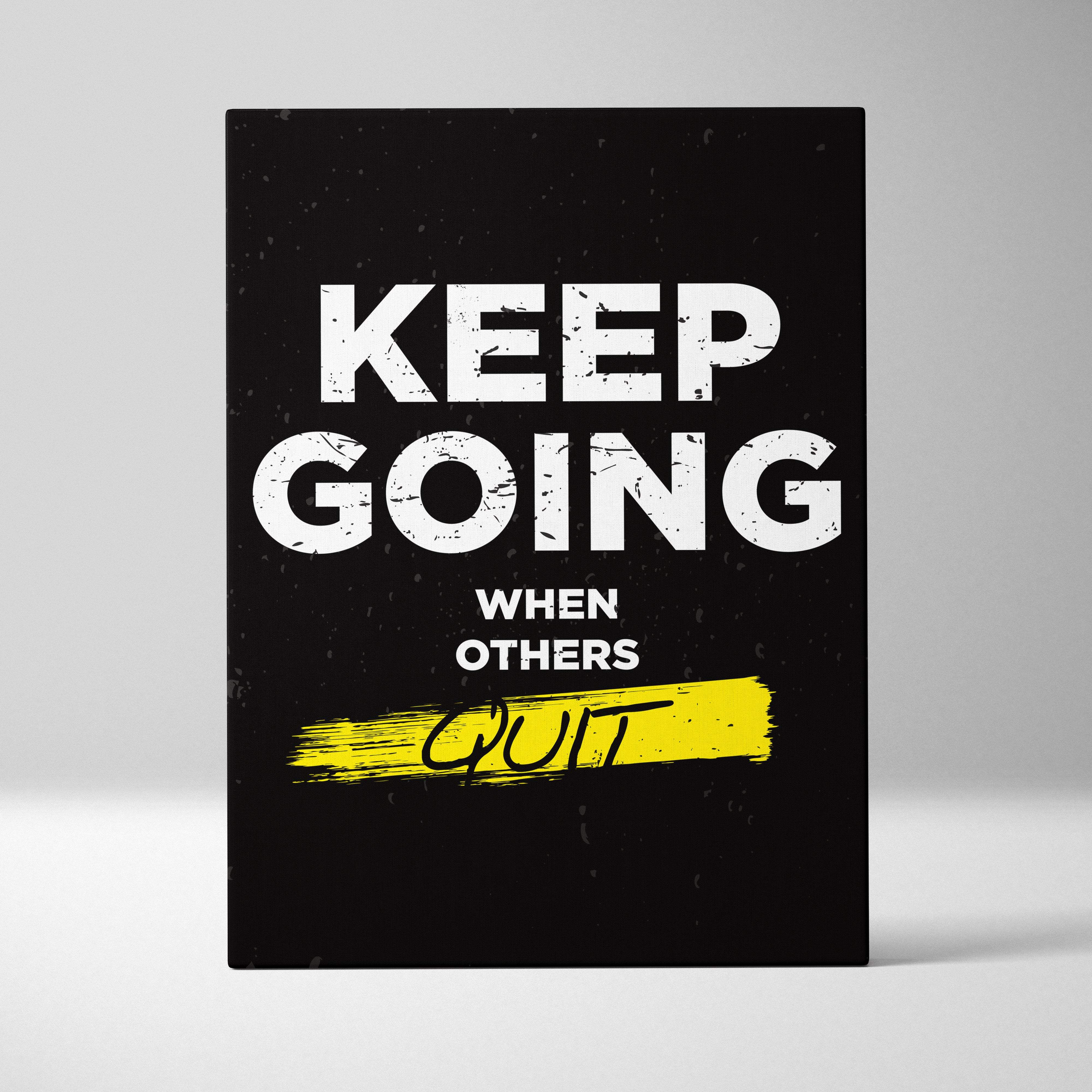 Black canvas print with bold white keep going when others quit phrase and yellow brushstroke for gym office or home decor