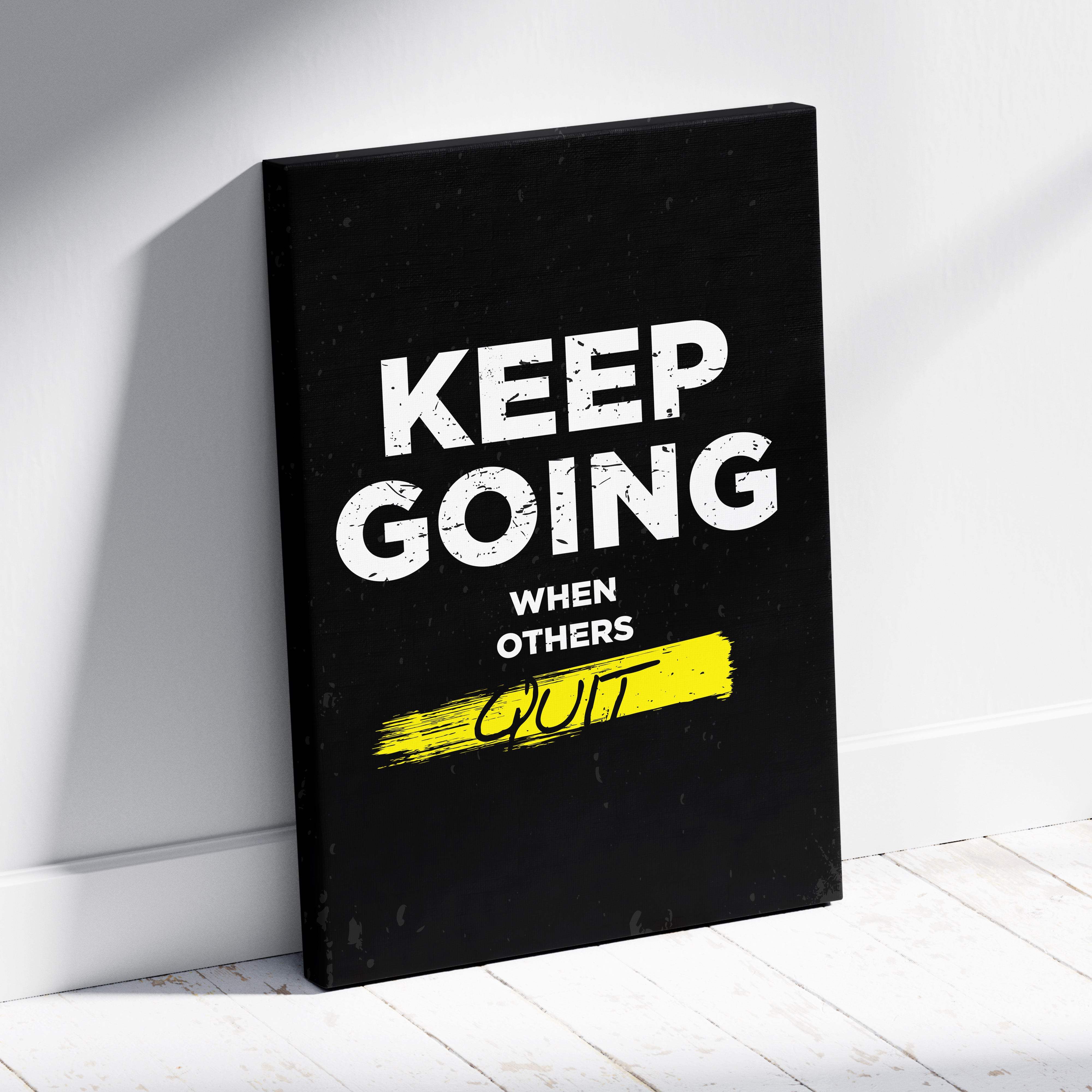 Black canvas print with bold white keep going when others quit text and yellow brushstroke accent for gym or office decor