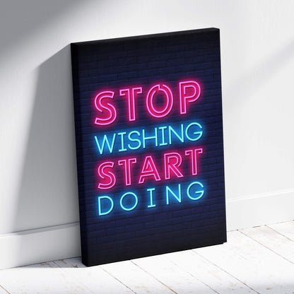 Stop wishing start doing motivational neon wall art print with vibrant pink and blue glowing letters on dark brick canvas