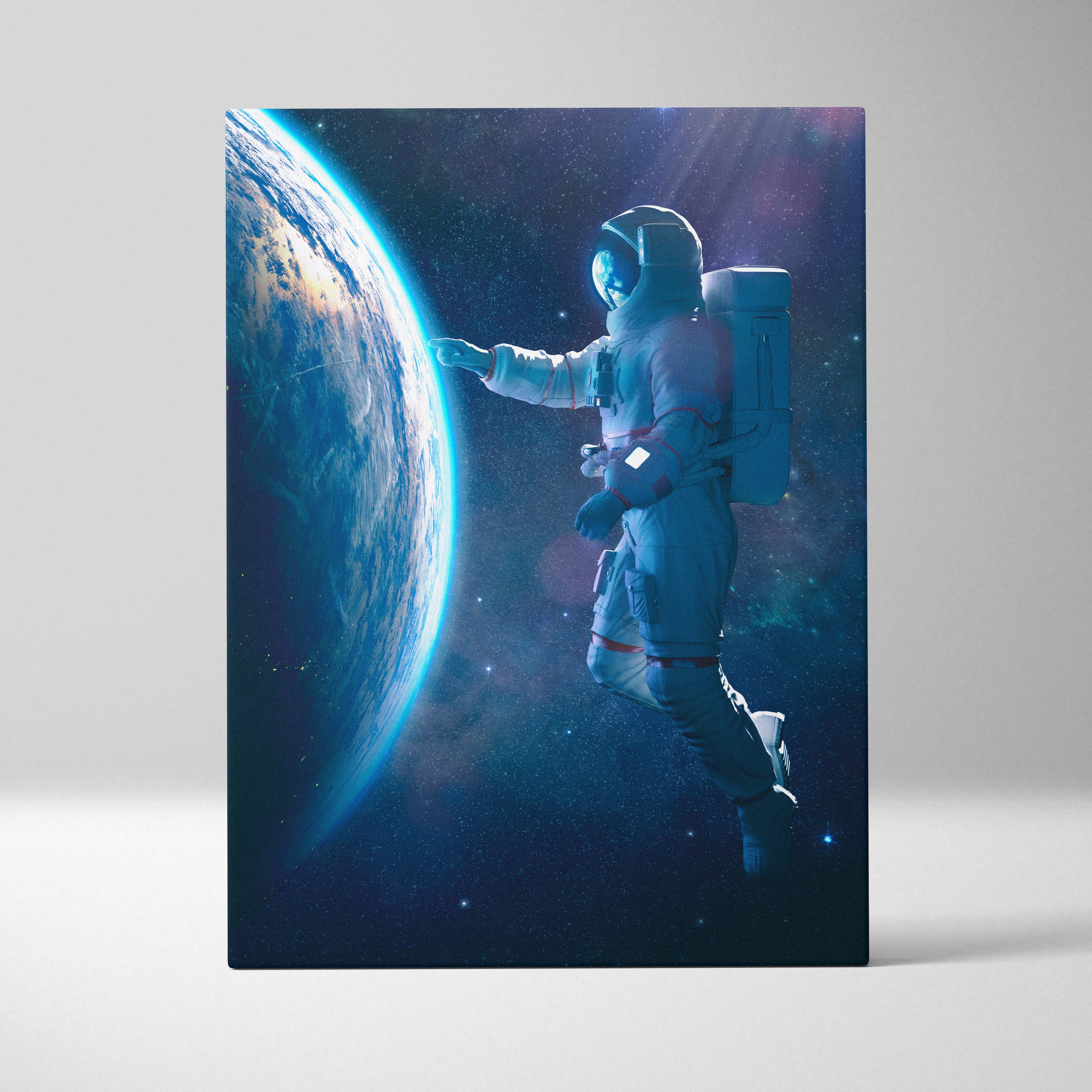 A rectangular canvas print of a floating astronaut near earth in a blue cosmic space scene wall decor