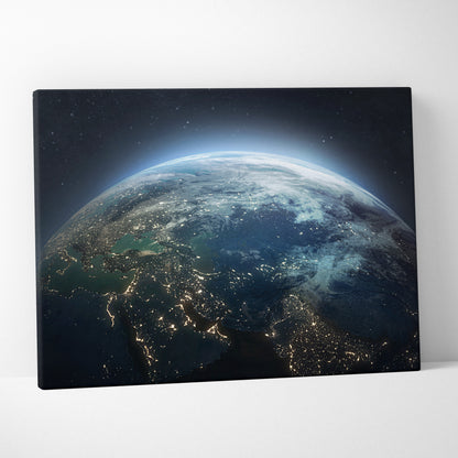 A rectangular canvas print of earth from space showing glowing city lights on dark blue ocean for modern office decor