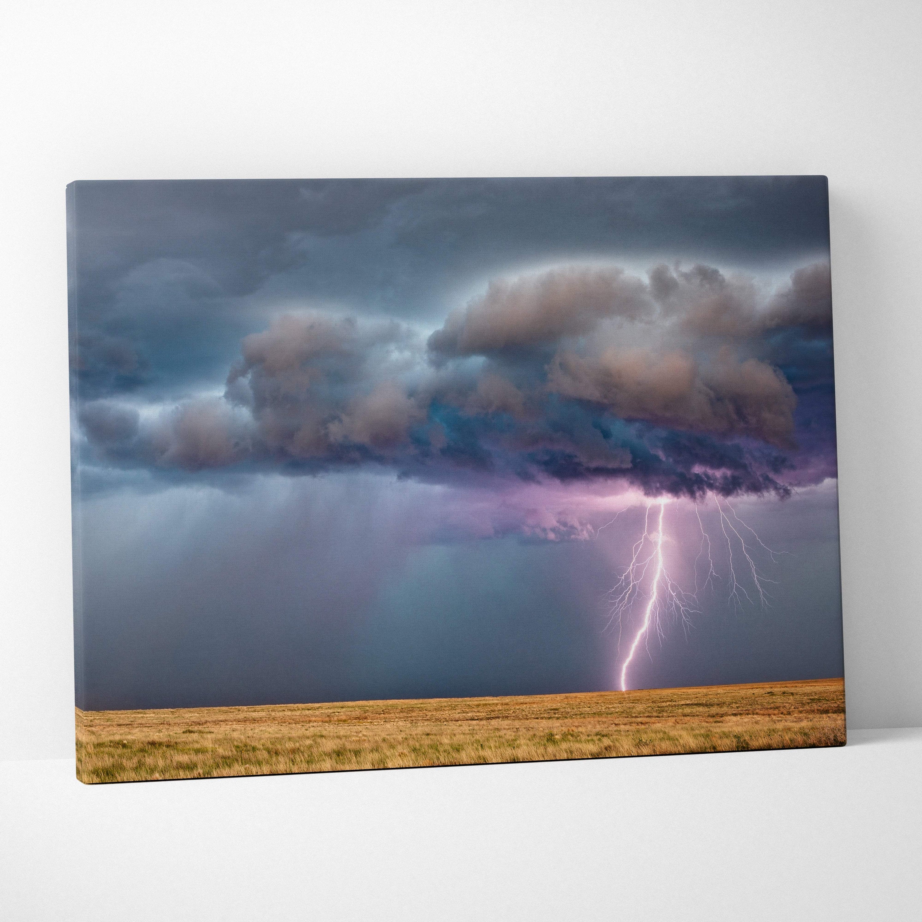 Canvas print of lightning strike over prairie with moody blue storm clouds and purple flash dramatic minimal landscape