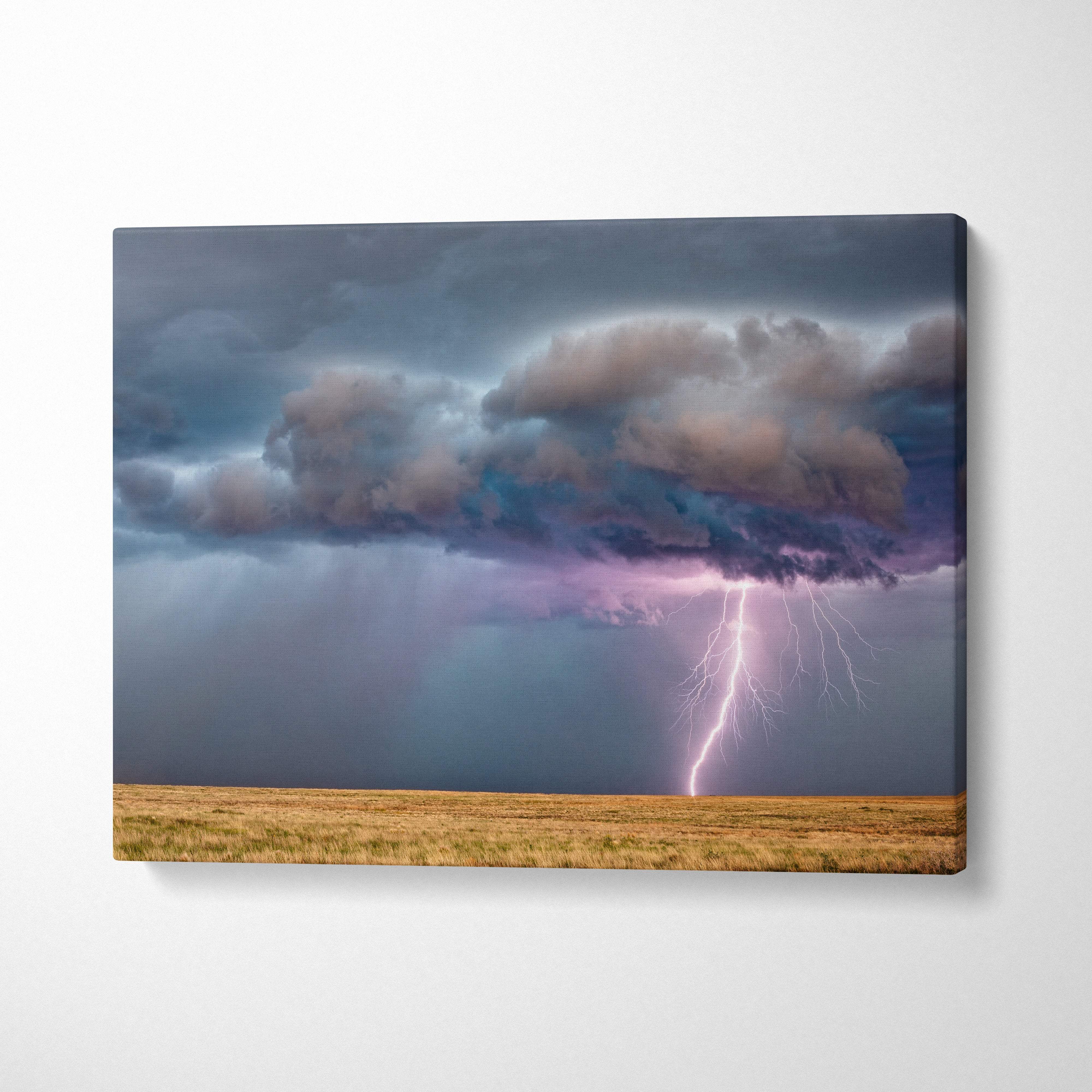 Canvas print of dramatic lightning strike over prairie with moody blue storm clouds and purple flash wall decor