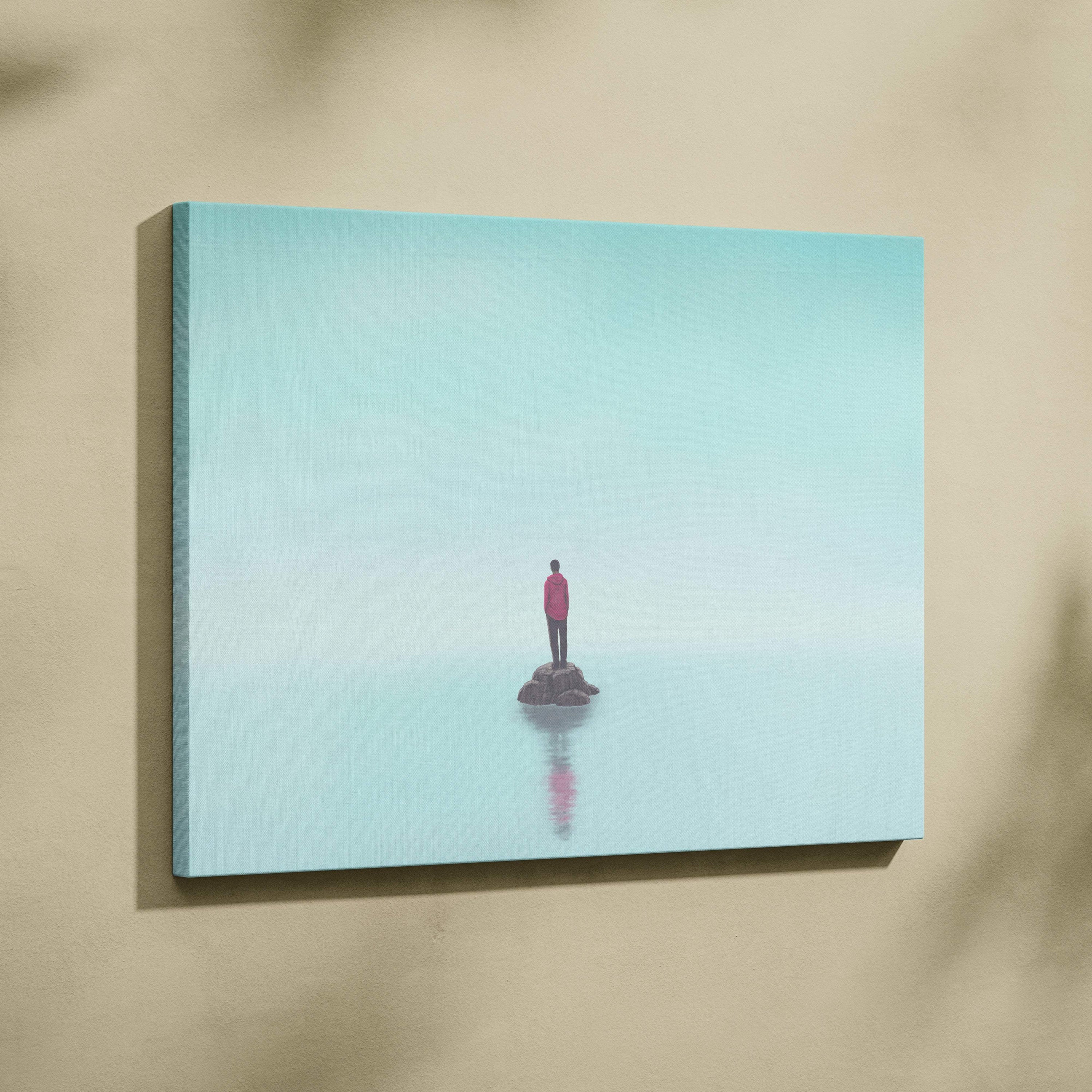 Contemporary lone figure canvas wall art of a vibrant pink shirt figure on dark rock reflected in turquoise water