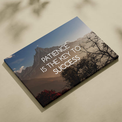 Motivational mountain canvas wall art with patience is the key to success quote in white on blue sky and brown mountains