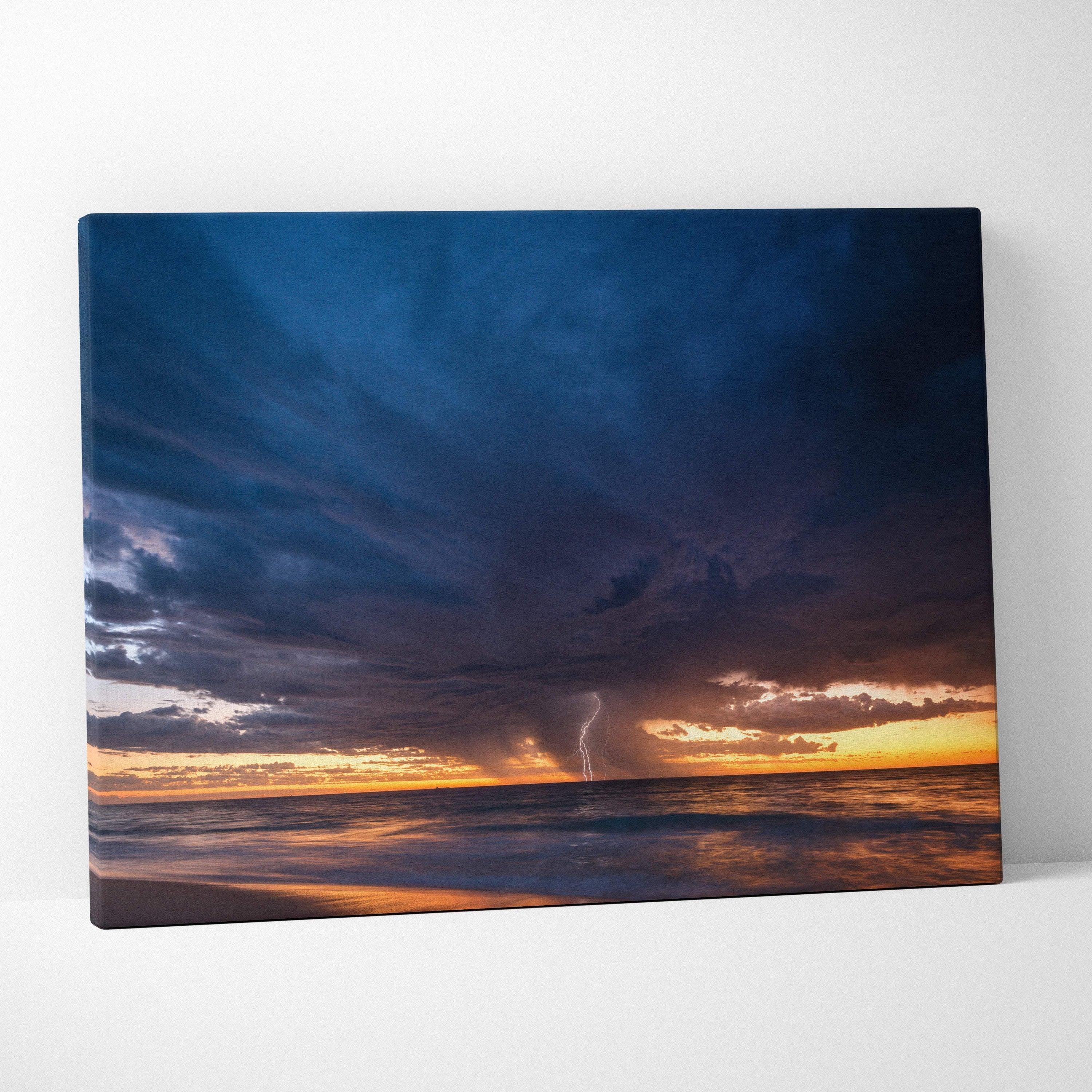 Stormy ocean sunset canvas art featuring deep blue clouds and golden horizon with lightning over sea at sunset