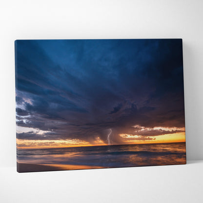 Stormy ocean sunset canvas art featuring deep blue clouds and golden horizon with lightning over sea at sunset