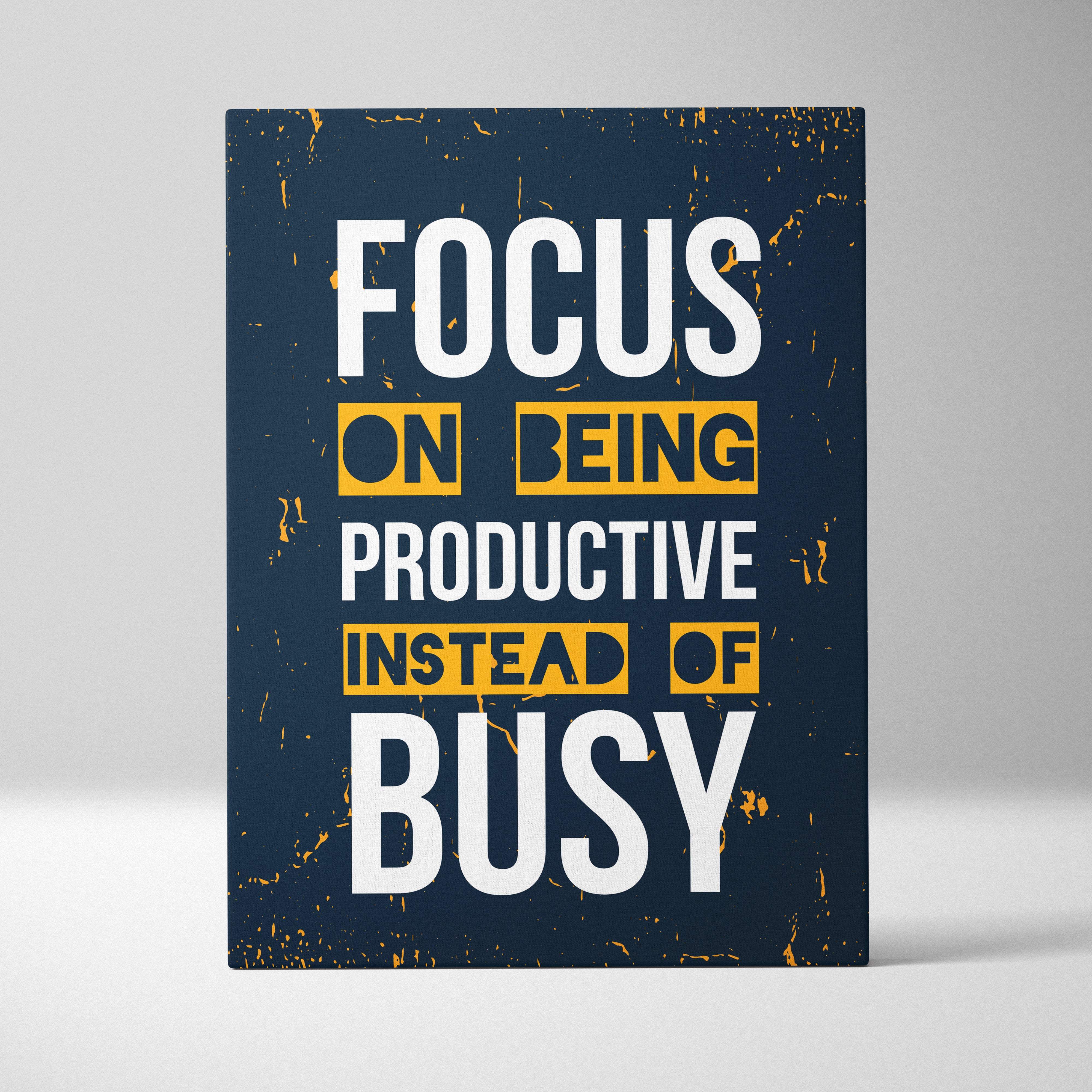 Navy blue canvas print with bold white and yellow motivational text focus on being productive instead of busy for office decor