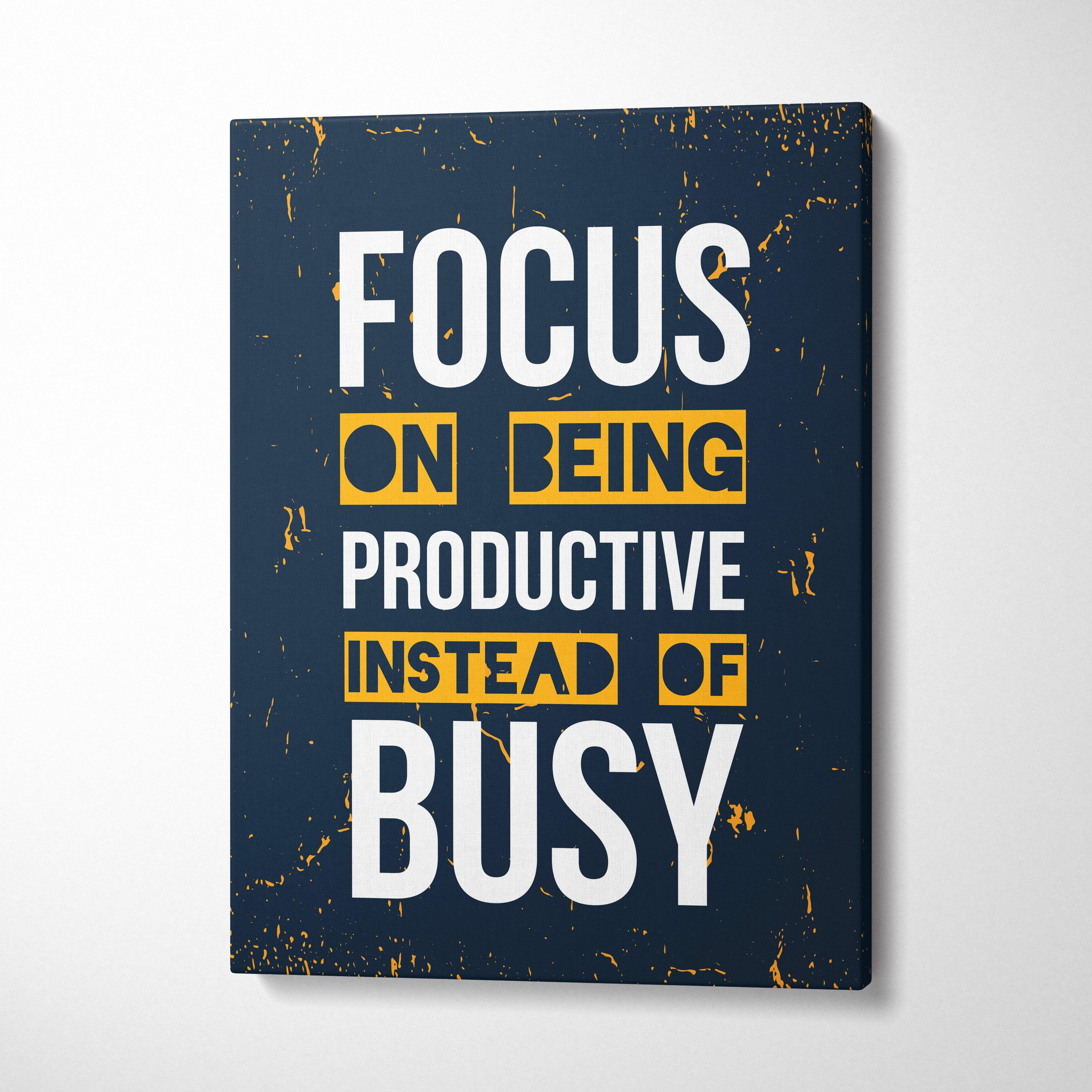Dark blue canvas print with bold white and yellow text focus on being productive instead of busy motivational wall art
