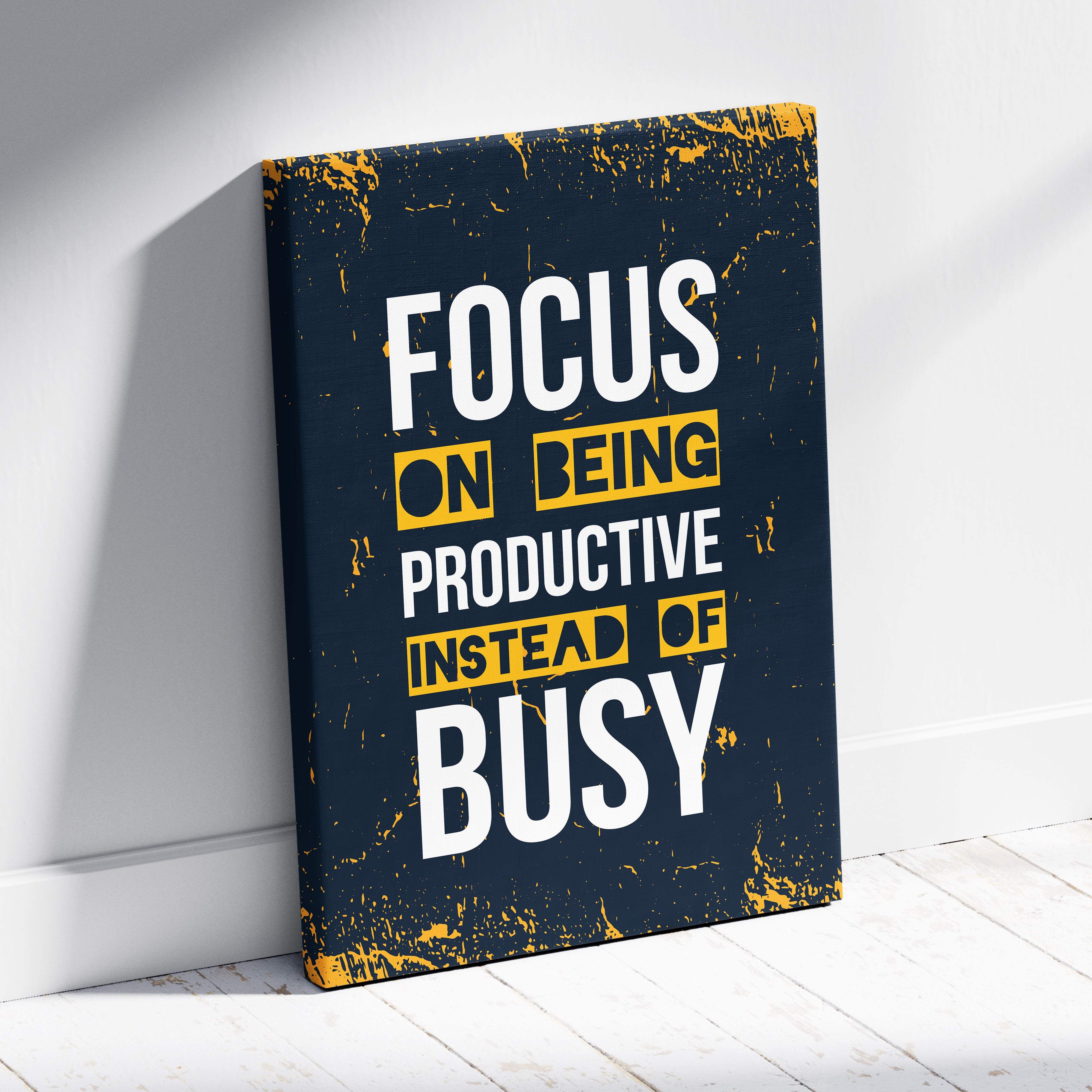 Dark blue canvas print with distressed yellow and white text focus on being productive instead of busy motivational wall art
